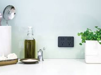 Black double power outlet installed in a modern residential kitchen splashback above the benchtop, showcasing a clean, compliant domestic electrical installation by Rotorua electricians, neatly integrated with everyday household use and contemporary décor.