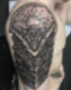Detailed shoulder tattoo of armored plates with a bear paw