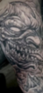 Detailed black and grey demonic tattoo with sharp teeth.