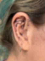handpoke ornamental dot tattoos on an ear