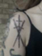 Three crossed daggers tattoo on a shoulder