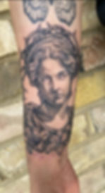Detailed portrait tattoo of a classical statue on a forearm