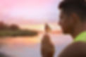 Man meditating near river at sunset. Space for text.jpg