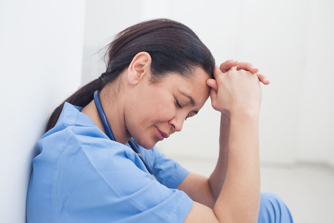 Upset nurse sitting on the floor in hospital ward, Healthcare workers in the Coronavirus C
