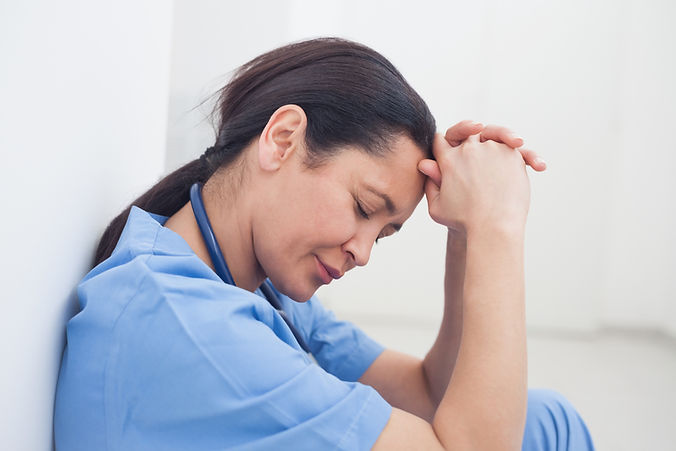 Upset nurse sitting on the floor in hospital ward, Healthcare workers in the Coronavirus C