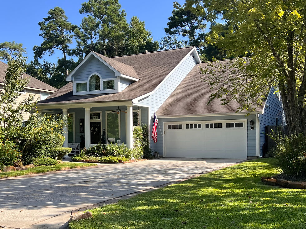 Quaint blue home with inviting front porch in the neighborhood of Cottage Green in the village of Alden Bridge in The Woodlands, Texas