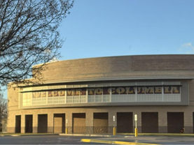 Brown building with banner that reads welcome to Columbia, background is a blue sky 
