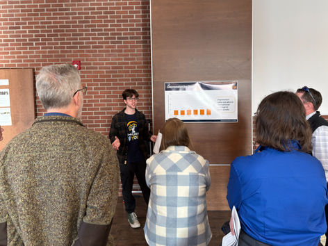 C4Y staff member presents a chart titled "Depression by Grade" to a group in a room with brick walls. Audience is attentive; casual setting.