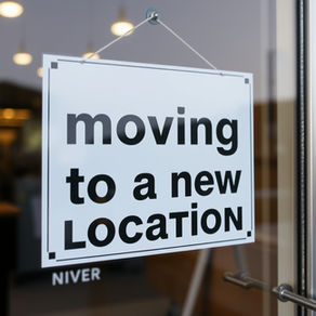 Sign on business door saying they are moving to a new location