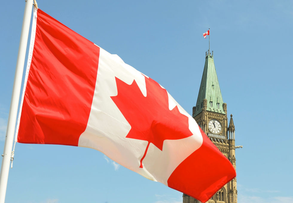 Canada flag flying over Parliament building