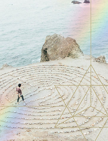 A person walking a labyrinth made of stones next to the ocean