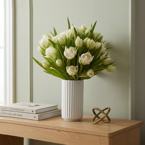 Bouquet de tulipes blanches Or Végétal, présenté sur meuble en bois clair.