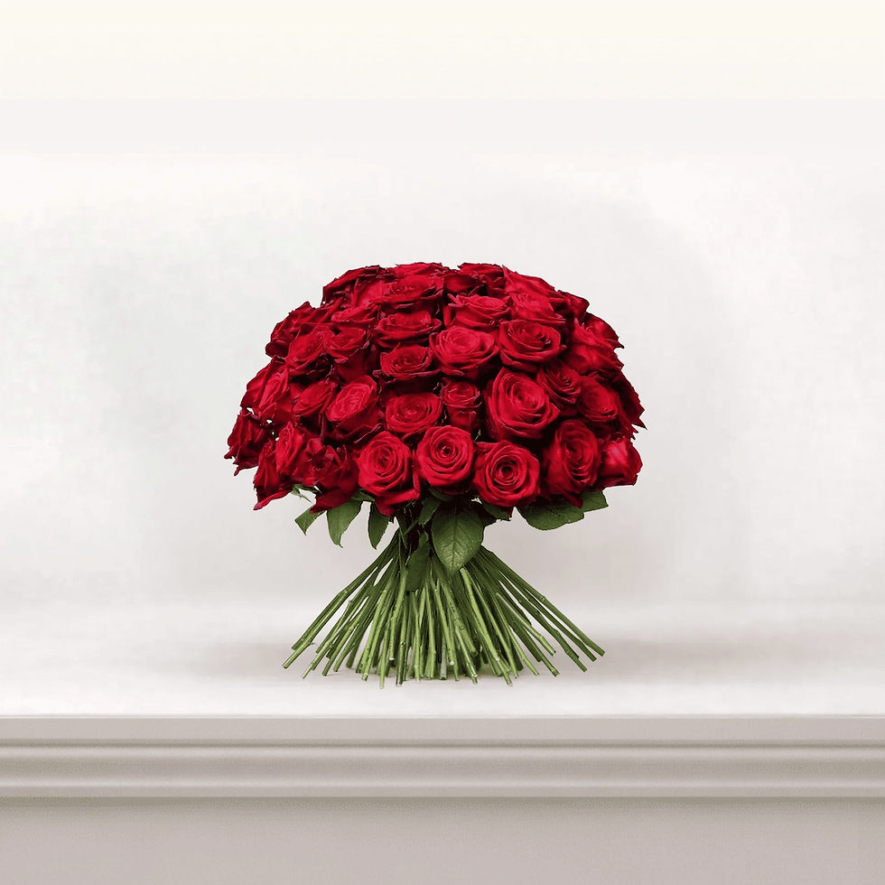 Bouquet de roses rouges posé sur une console, tiges apparentes et silhouette basse, effet “dôme” très généreux.