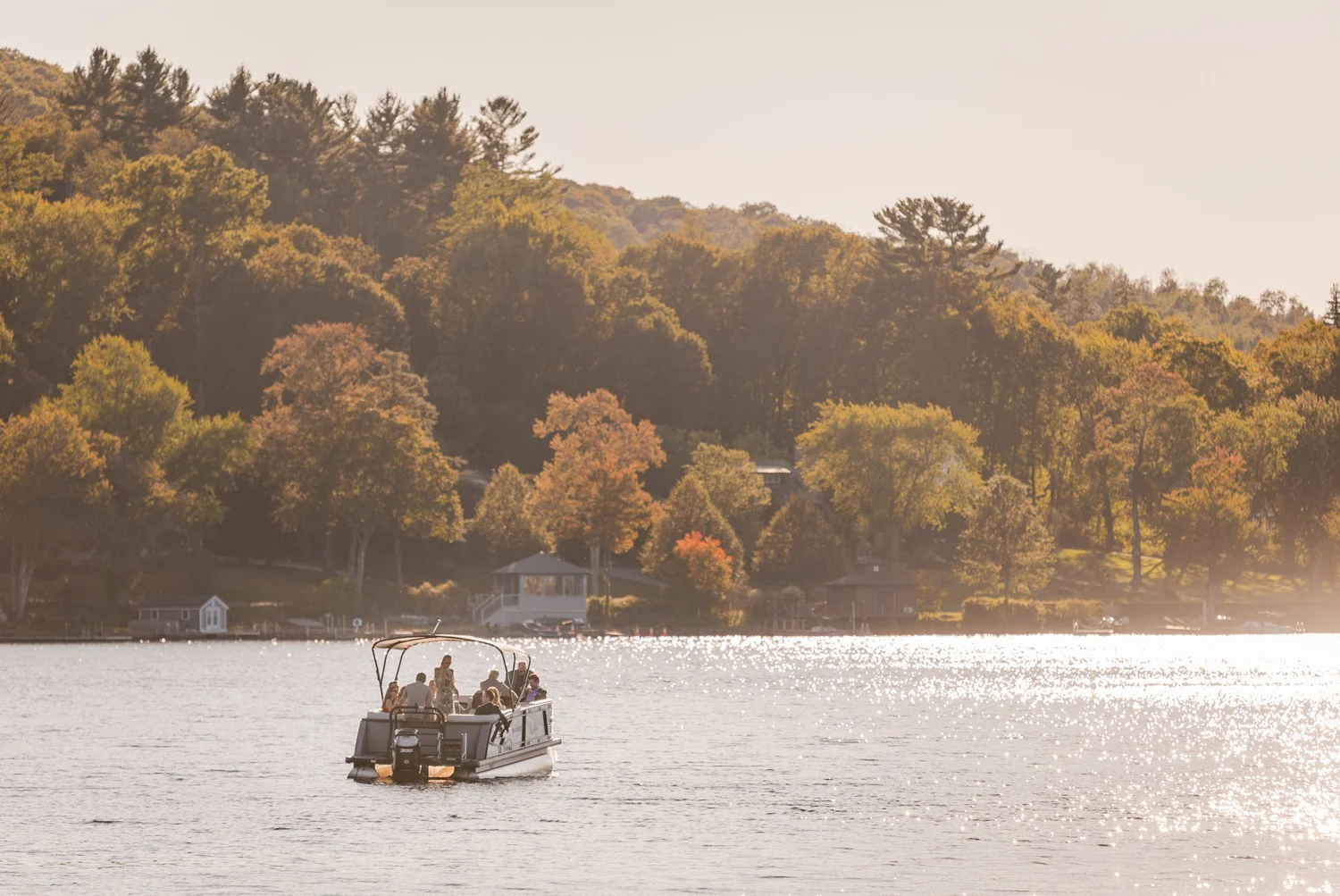 Guests arriving at a lakefront wedding reception by boat, a 2026 wedding trend