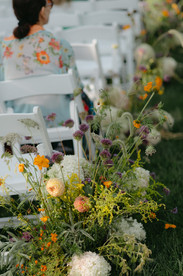 Meadow floral arrangements creating a romantic ceremony aisle, a 2026 wedding trend