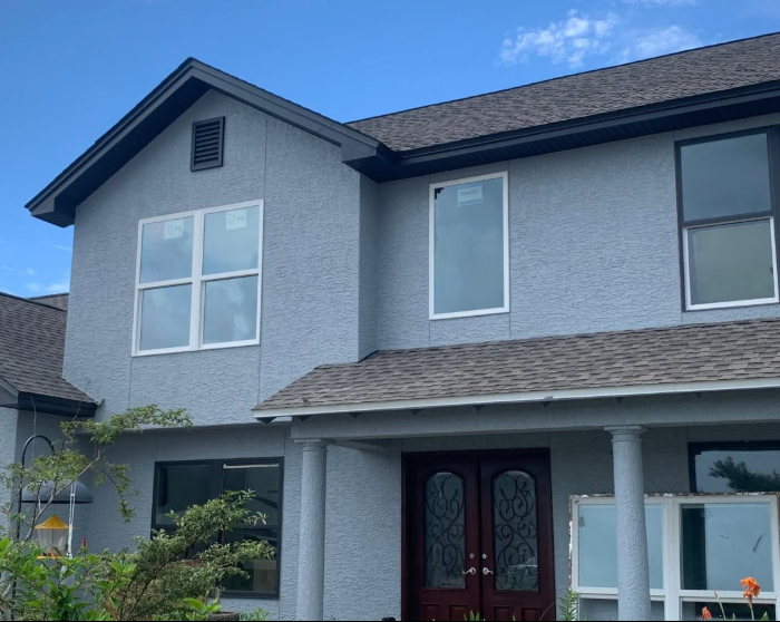 New construction home with finished gray stucco exterior