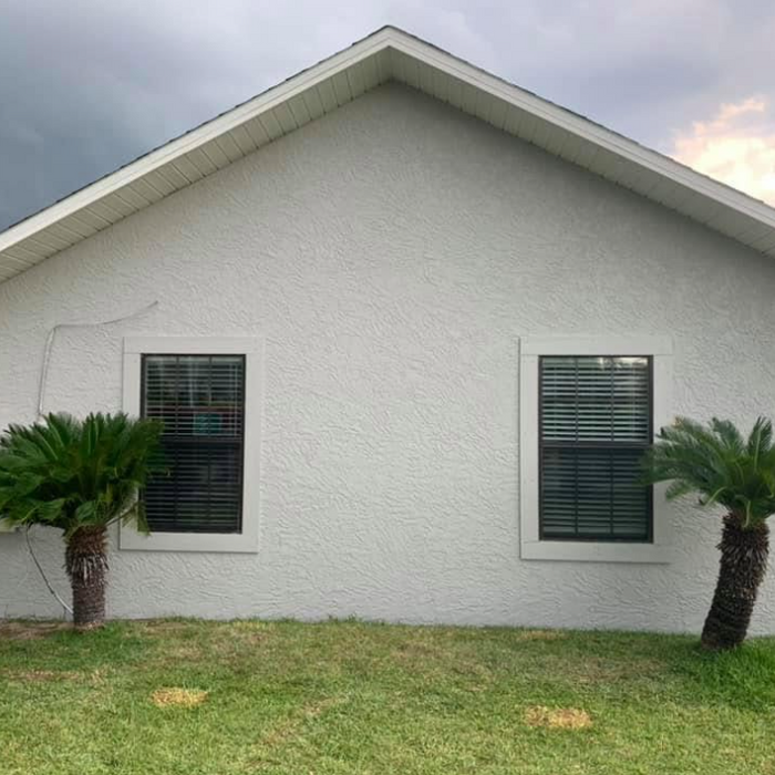 New construction home with finished gray stucco exterior