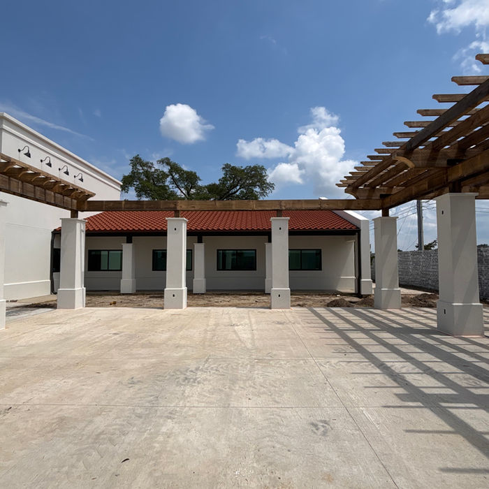 Commercial stucco building with completed exterior finish and concrete driveway