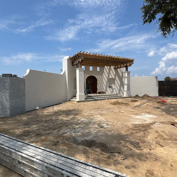 Stucco construction project with exterior walls and entryway in progress
