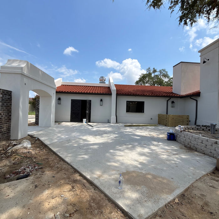 Residential stucco project with newly completed driveway and exterior finish