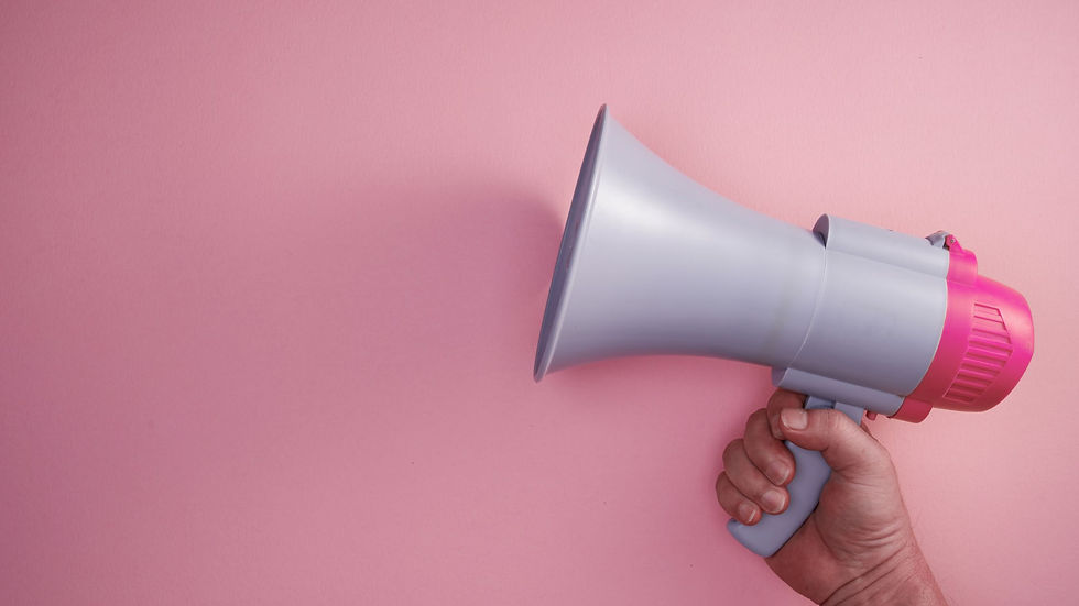 Hand holding a gray and pink megaphone against a pink background, suggesting communication or announcement.