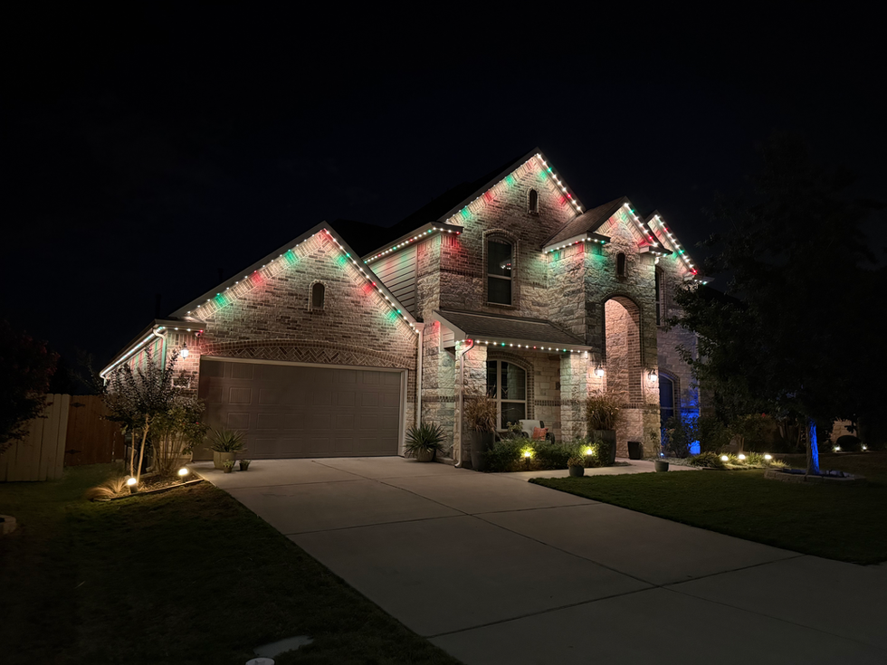 TruLight permanent roofline lighting displaying red, green, and white holiday colors on a home
