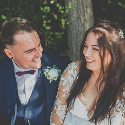 Bride and groom sat outdoors smiling