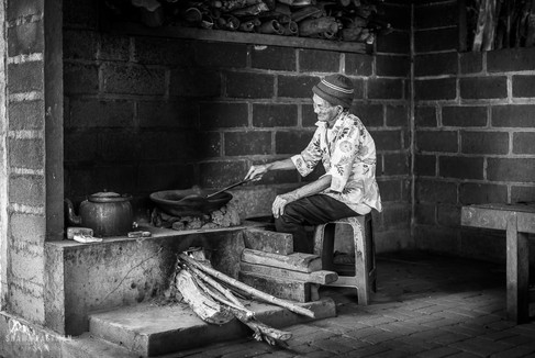 Elderly woman making coffee at plantation in Bali, Indonesia
