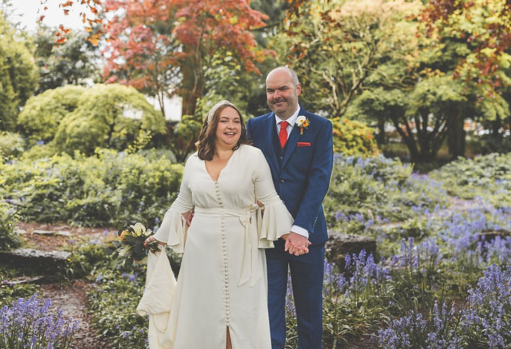 Bride and groom outdoors holding hands on wedding day in garden at Insole Court in Cardiff