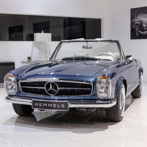 Front left view of an electric blue Mercedes-Benz 280SL Pagoda in a showroom