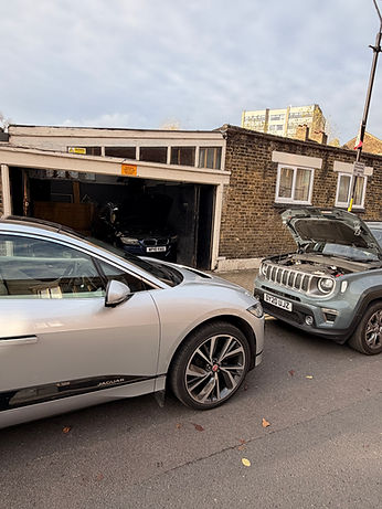 Two cars outside of a garage