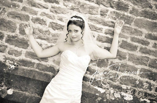 Bride posing against a brick wall