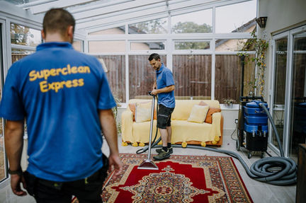 Superclean Express staff cleaning a red patterned rug