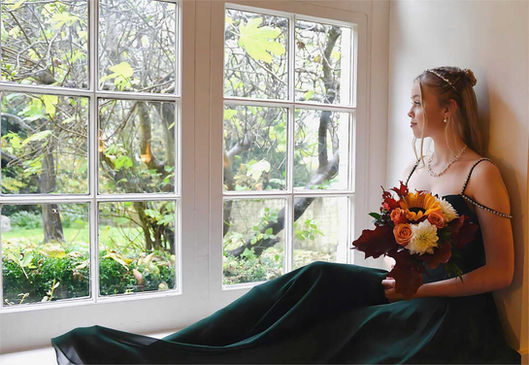 Bridesmaid sat by a window looking out