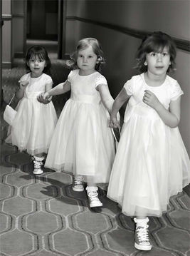 Three little girls dressed up for a wedding