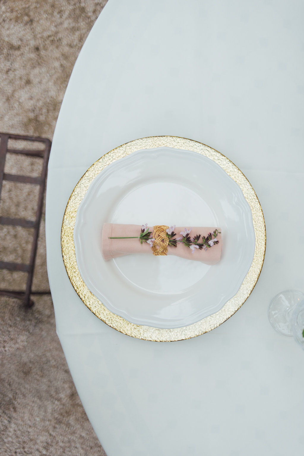 Onderbord met gouden rand en lichtroze servet met rozemarijn