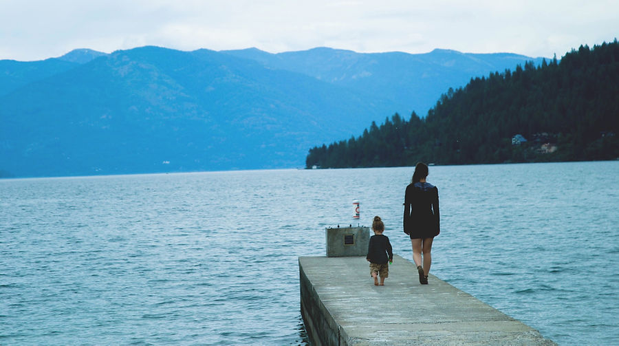 A woman and a child walking along a pier towards the end of the pier. There are mountains and a forest in the back ground. This represents the healing of the inner child. Our inner child always walks along side us waiting to be acknowledged and integrated back within ourselves so that we can come into wholeness of ourselves.