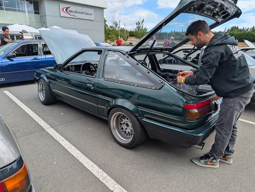 Mid 30 year old male working a Toyota AE86 at the race track