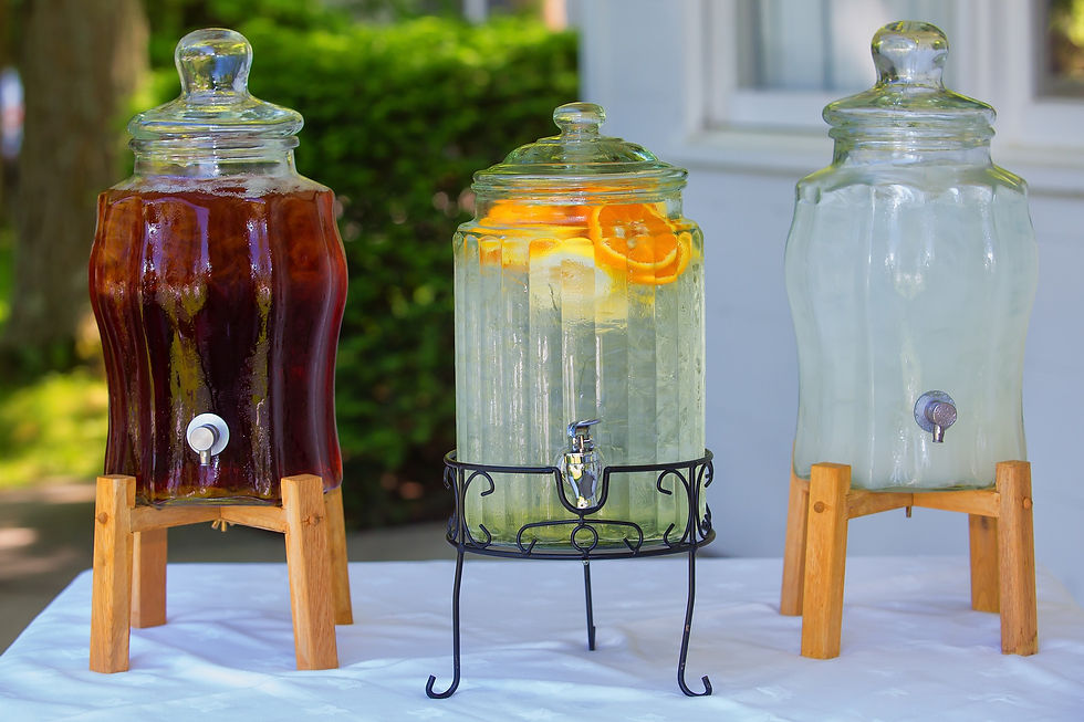 Three glass pitchers of sweet tea, lemonade and flavored water