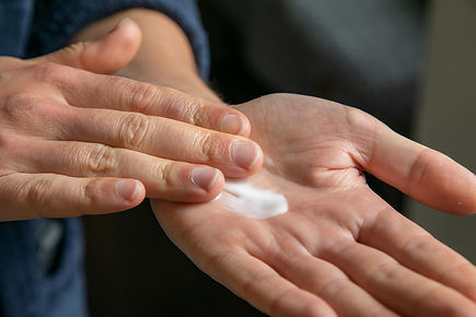 close up photo hands rubbing palm of lotion together