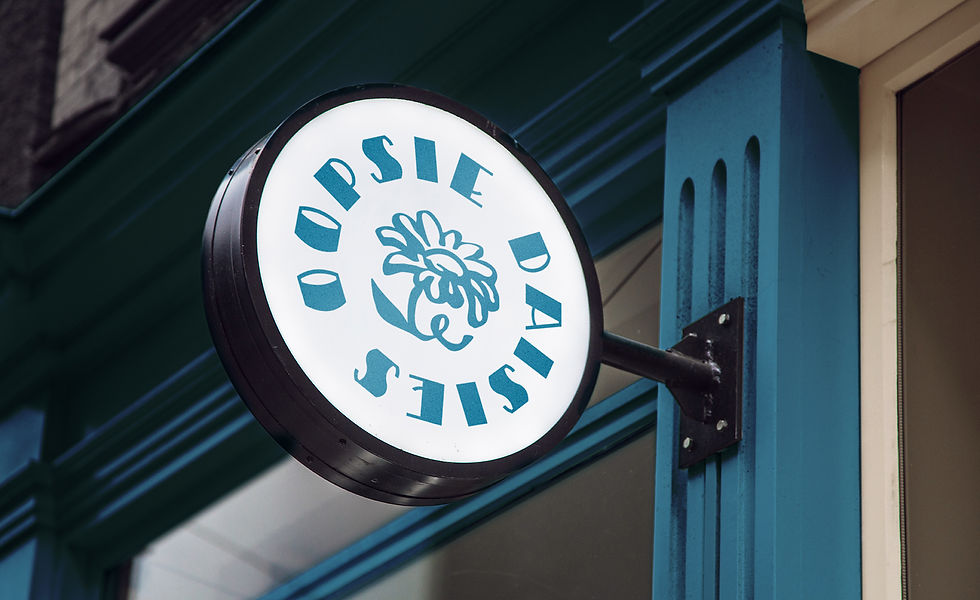 looking upwards at custom exterior signage oopsie daisies with daisy illustration attached to blue building