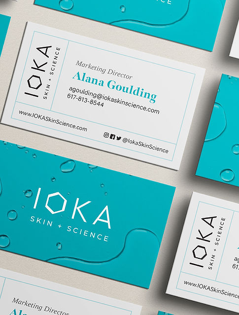 custom designed business cards in white and teal on a cream background in overhead isometric view