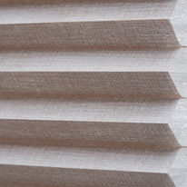 Nahaufnahme eines Duette Plissees mit wabenförmiger Struktur in Beige und Weiss.