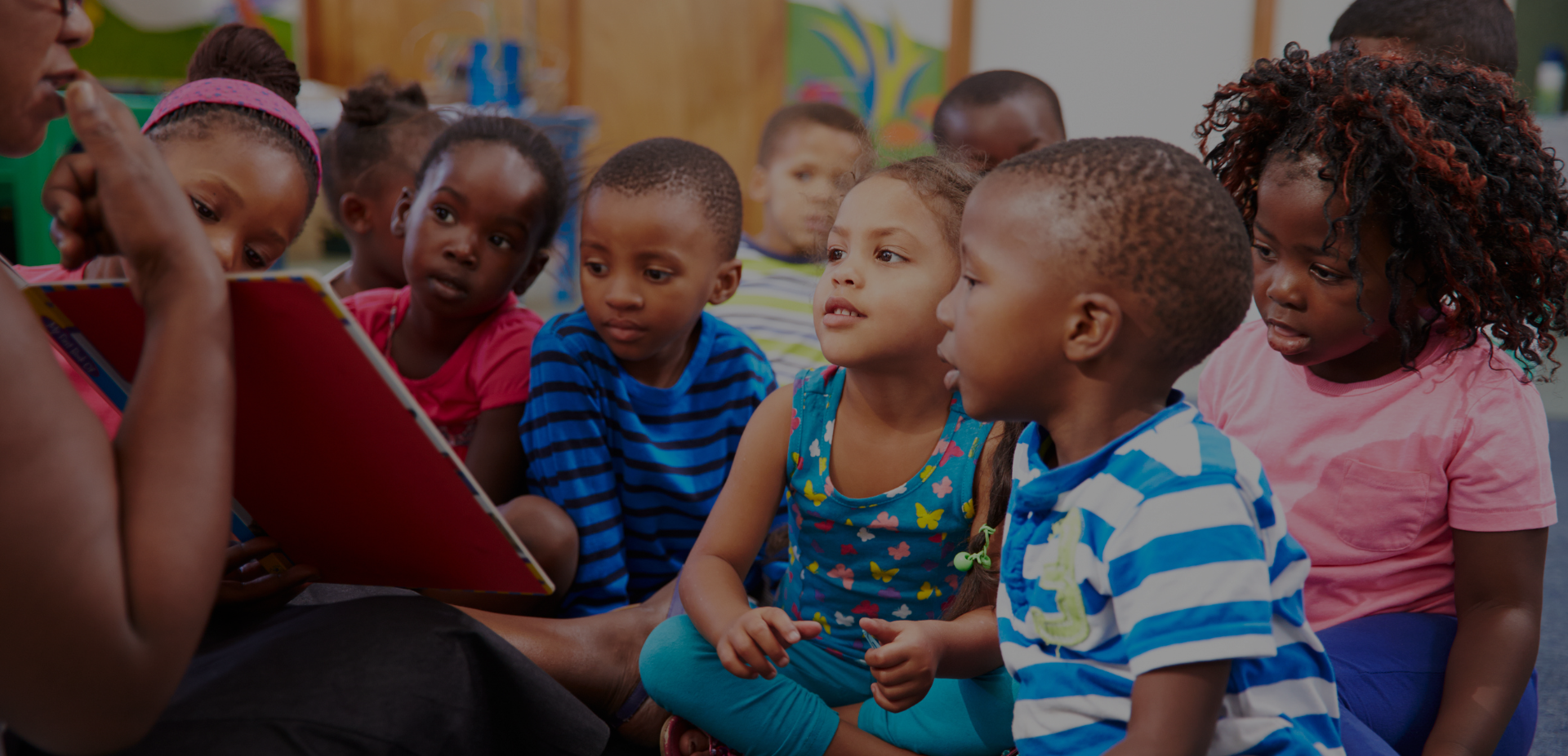 Diverse group of children sitting together during story time or educational activity in classroom setting