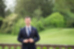 Vincent Sanderson in a navy suit standing in a garden