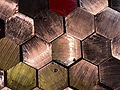 Hexagonal copper and industrial metal alloy samples showing brass, bronze, and various metal compositions used in machinist and industrial applications