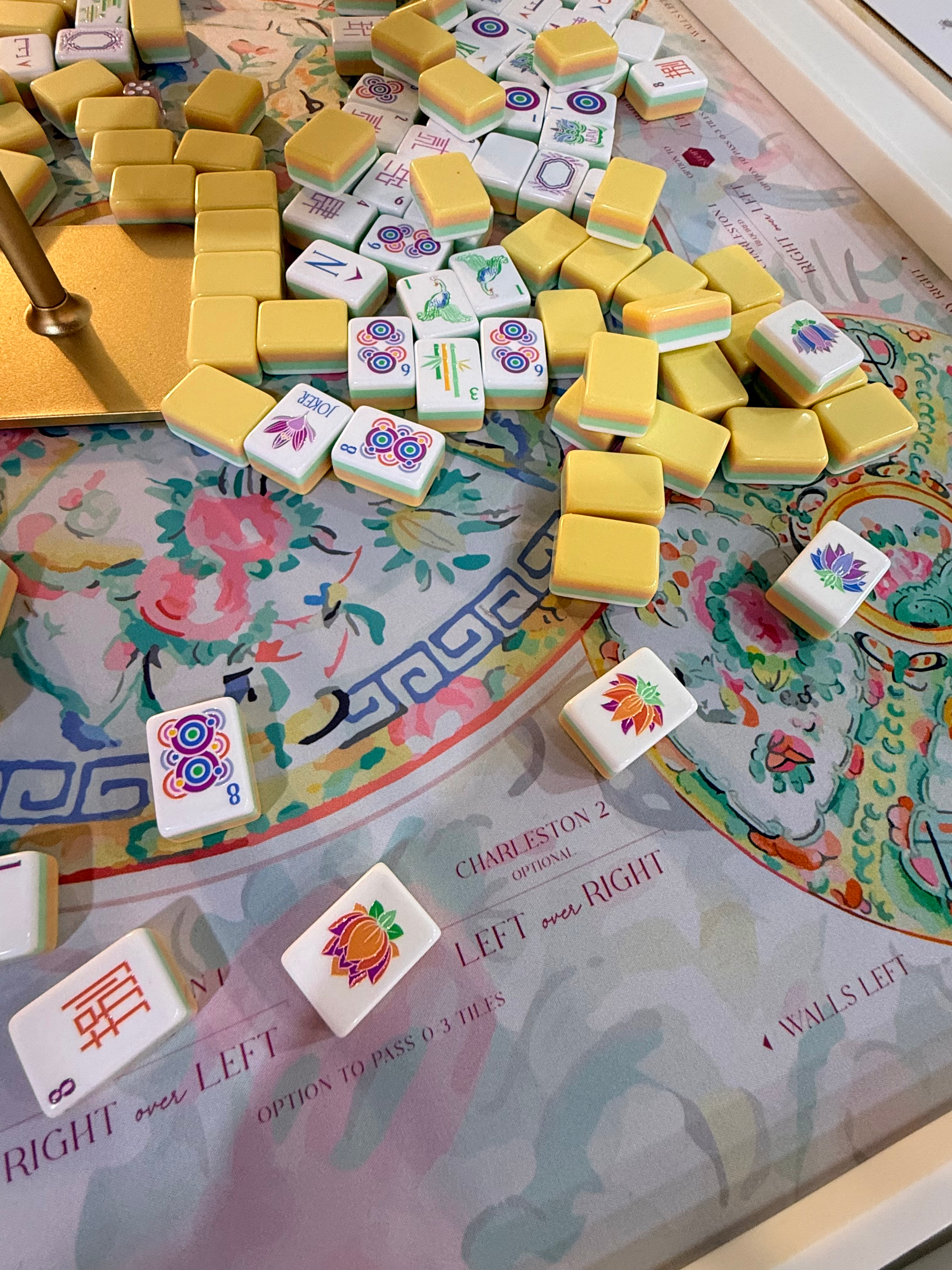 Mahjong tiles scattered on a colorful, patterned mat