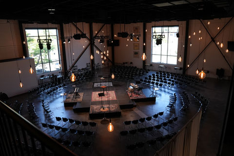 Overview of church sanctuary with intimate stage setup and pendant lighting