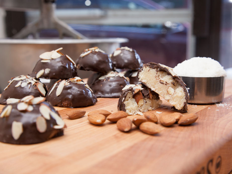 Chocolate-covered almond treats, sliced open, surrounded by almonds, Cookie Time Bakery.