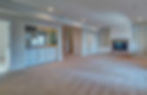 Spacious unfurnished basement room with wet bar, fireplace, and built-in shelves